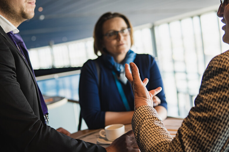 Das Foto zeigt drei Menschen, die miteinander diskutieren.